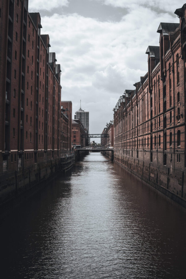 Kanal zwischen roten Backsteinfassaden unter bewölktem Himmel